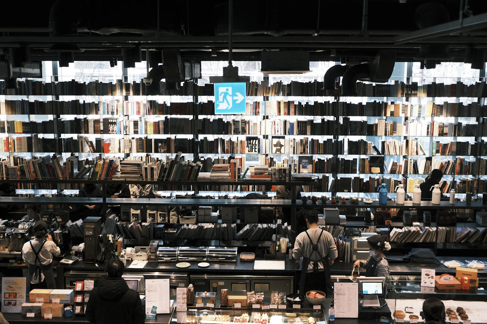 A real book café with illuminated bookshelves and a lively service counter.